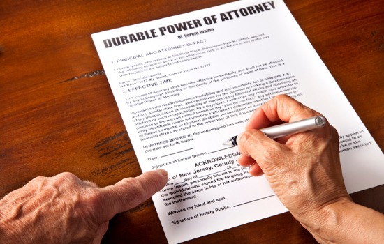 An elderly man signing a document for Power of Attorney in Charleston SC