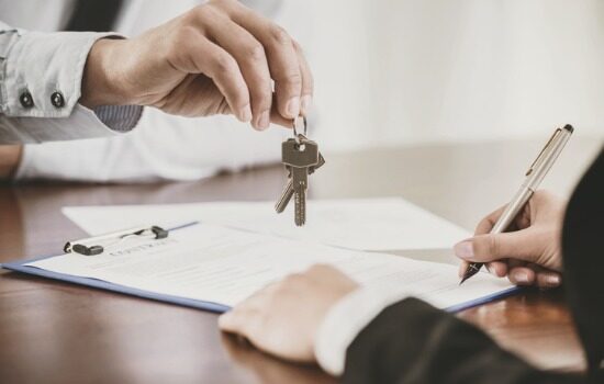 An attorney handing house keys to client after facilitating the sale's closing
